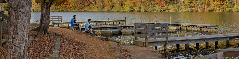 Older dad show sitting by lake thin photo.